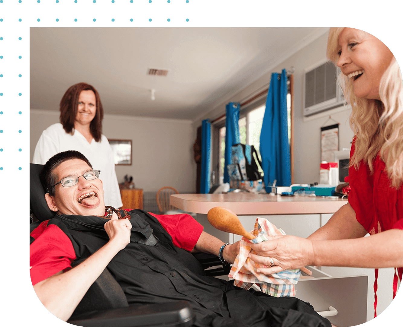 A man in wheelchair smiling at another person.