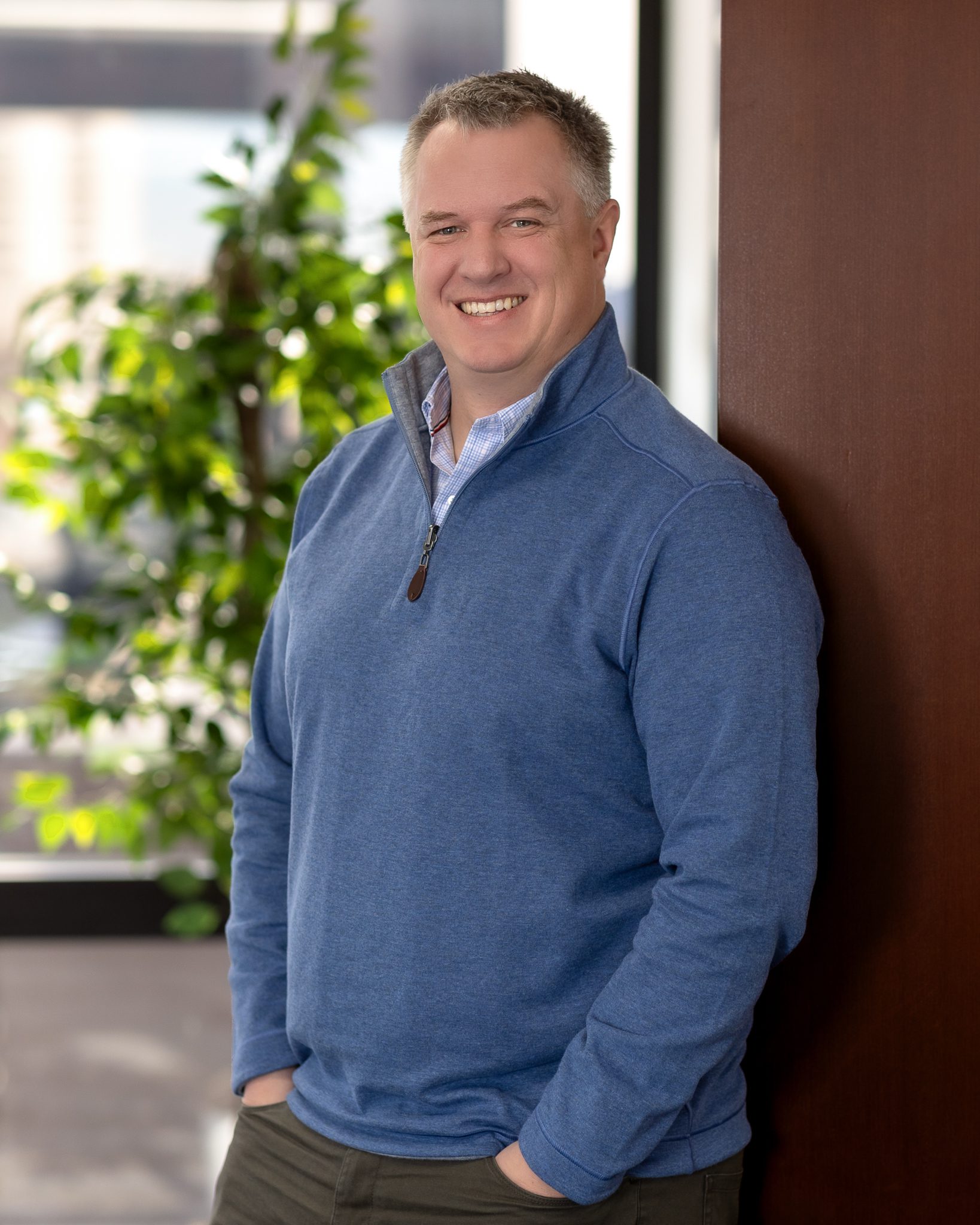 A man standing in front of a wall with his hands in pockets. A man standing in front of a wall with his hands in pockets.
