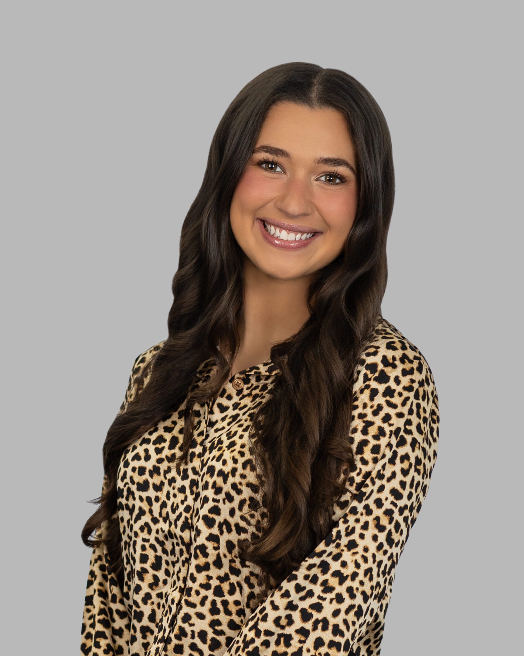 Catie_Kimball-80-Print A woman in leopard print shirt smiling for the camera.