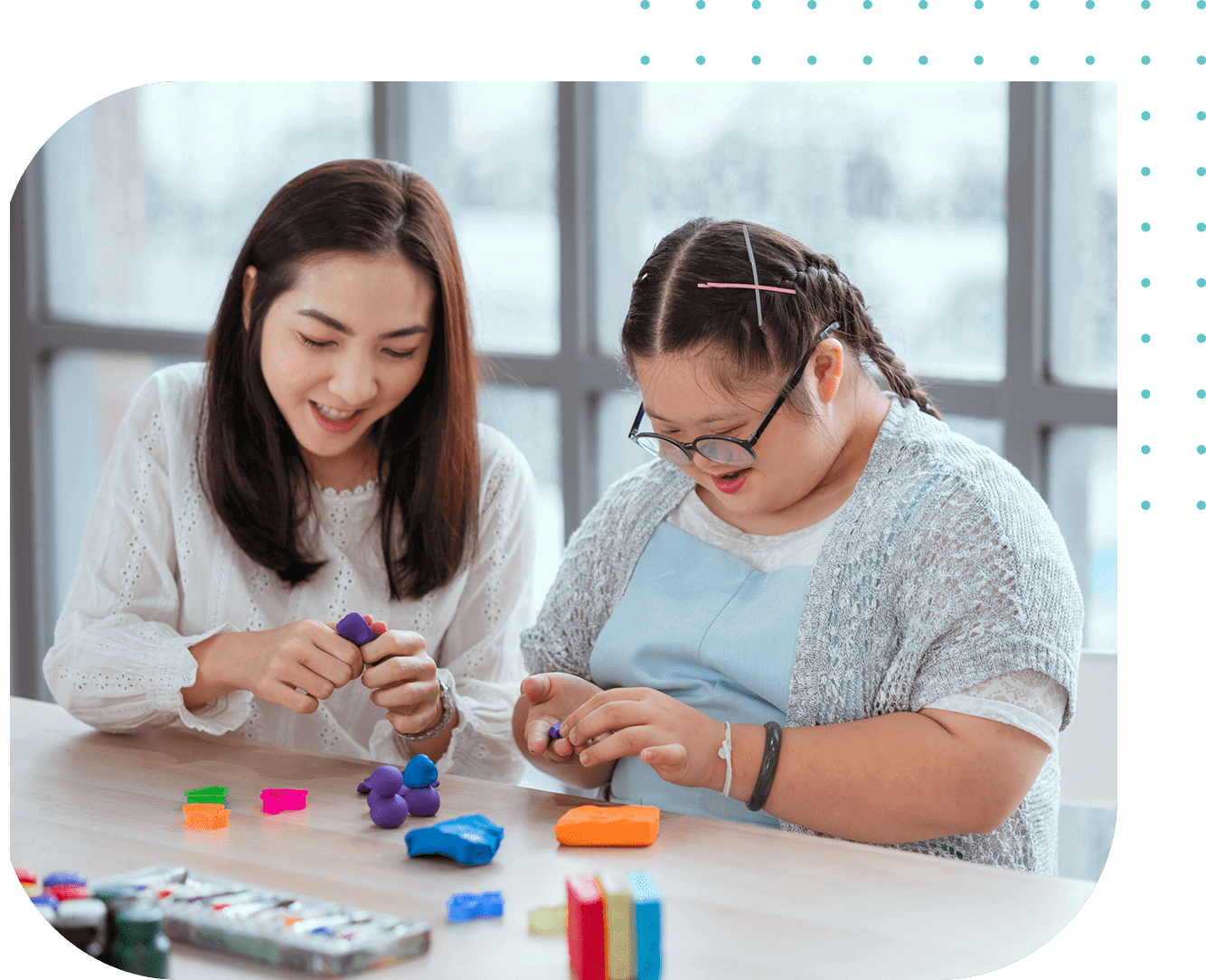 Two women sitting at a table with some toys.