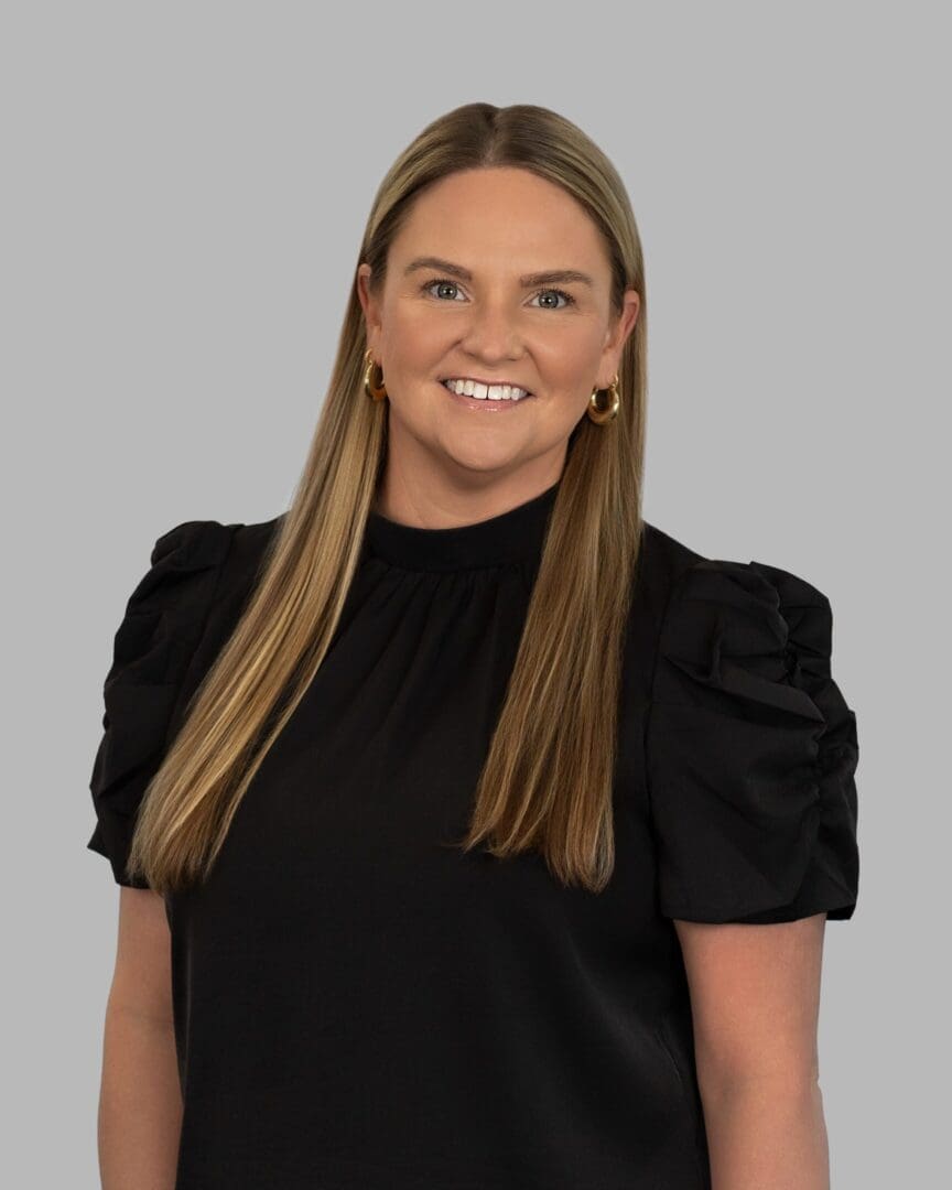 A woman in black shirt smiling for the camera. A woman in black shirt smiling for the camera.